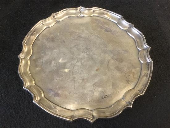 Circular silver salver, with piecrust edge and scrolled feet, Sheffield 1917